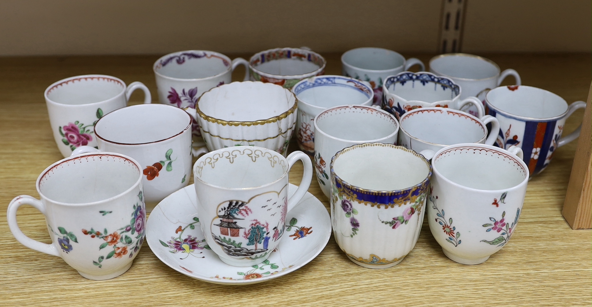 A collection of late 18th century Worcester and Lowestoft coffee cups and a saucer, many hand painted with flowers, the largest 12cm in diameter